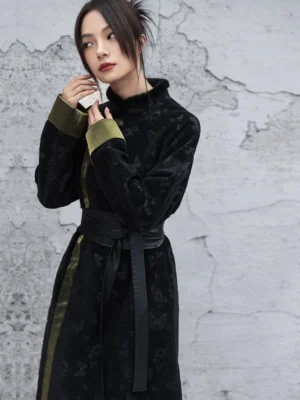Front three-quarter view of a vintage black modern Hanfu long dress with dark butterfly jacquard, olive green contrast cuffs, fuzzy stand collar, and black waist belt