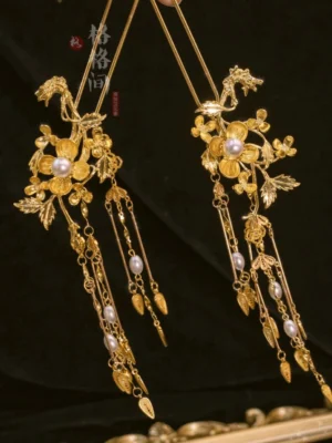 Pair of vintage Chinese bridal hair pins with gilded floral filigree, pearl centers, chain tassels, and leaf-shaped charms
