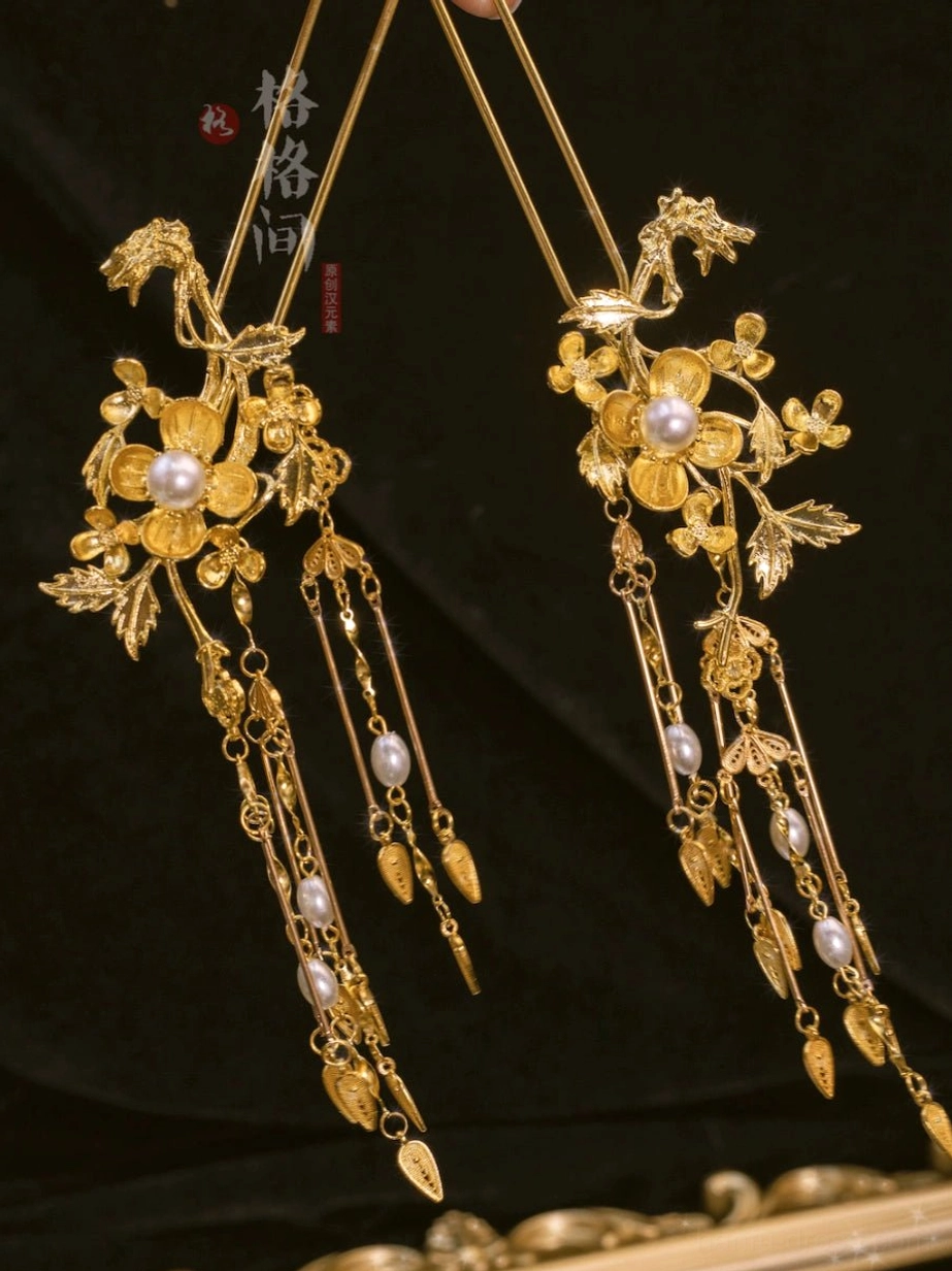 Pair of vintage Chinese bridal hair pins with gilded floral filigree, pearl centers, chain tassels, and leaf-shaped charms