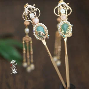 Side view of vintage Chinese Hanfu hairpins with green gem accents imitation pearls hollow floral tops and dangling chain tassels