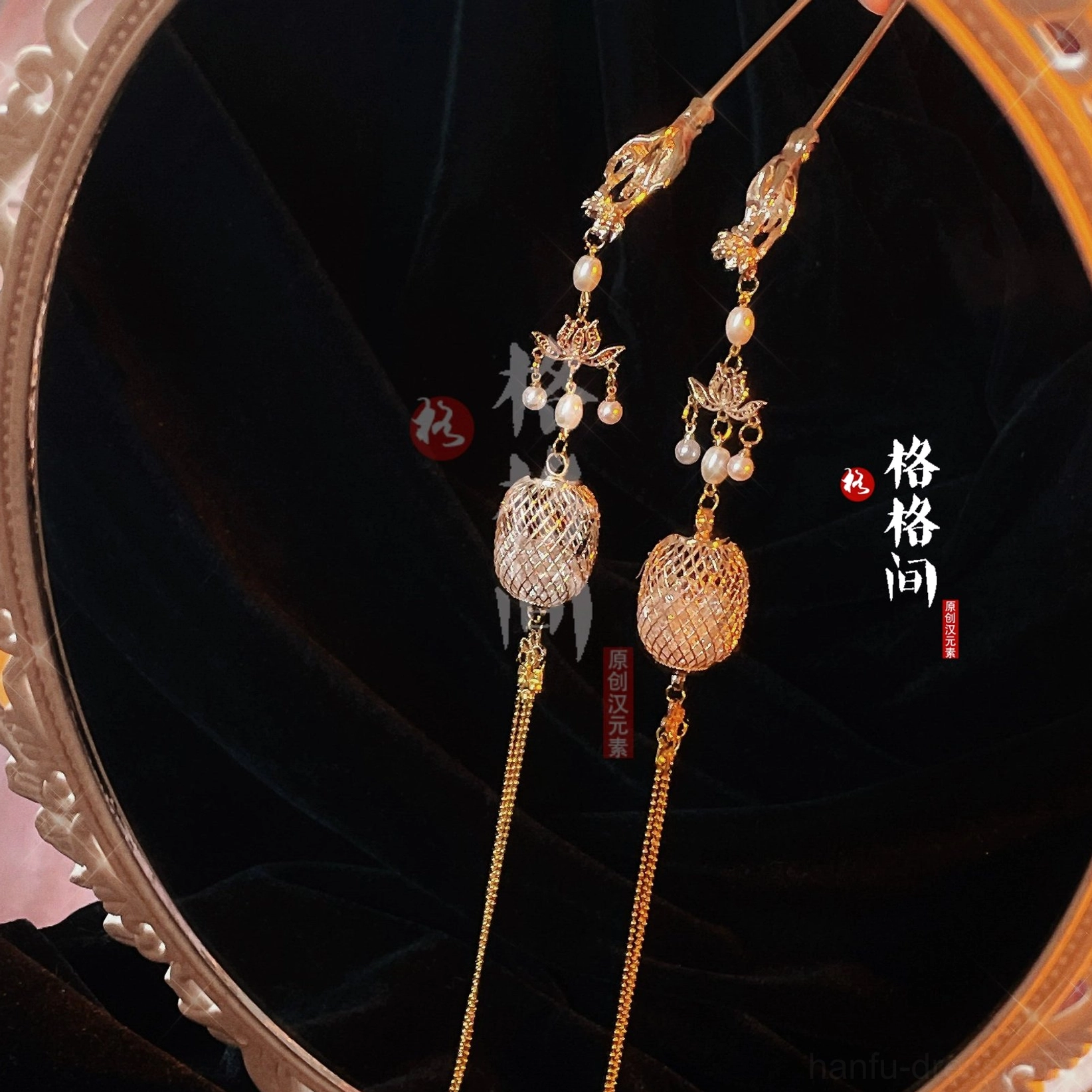 Pair of vintage Chinese lantern tassel hair pins with gold toned hollow lantern pendants pearl accents and long chain tassels displayed on a round mirror