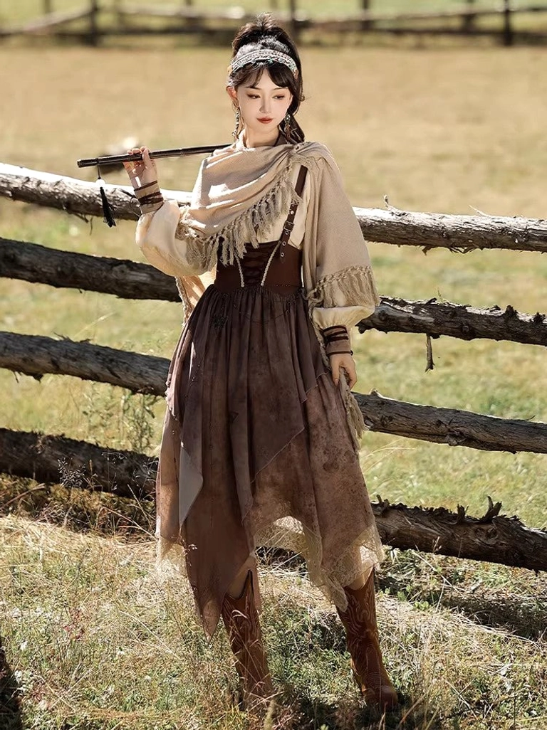 Front view of a vintage-inspired modern Hanfu set with solid brown corset waist, irregular lace-edged skirt, tasseled shoulder shawl, pearl headband, and Western boots beside a wooden fence