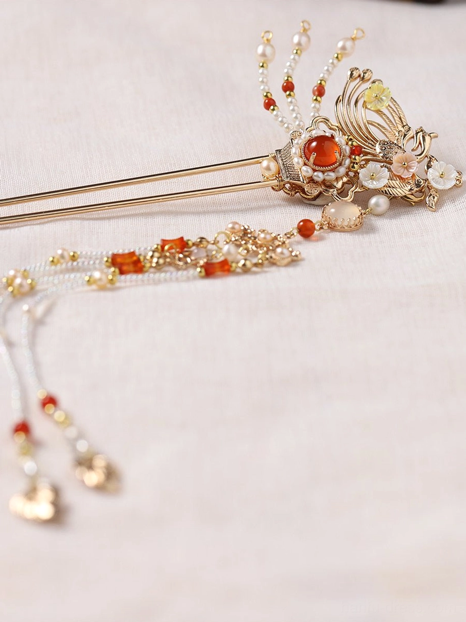 Close-up of vintage inspired gold phoenix Chinese hair stick with red decorative stone and delicate beaded tassel pendants