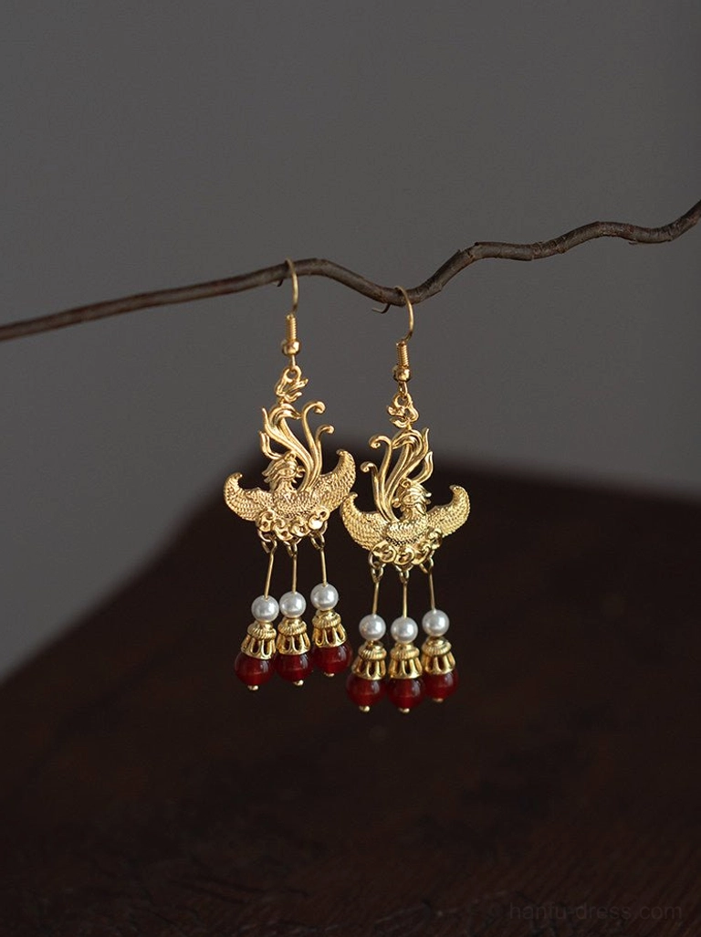 Vintage phoenix Hanfu dangle earrings with delicate phoenix ear hooks pearl drops and red bead tassels displayed against a dark wooden background