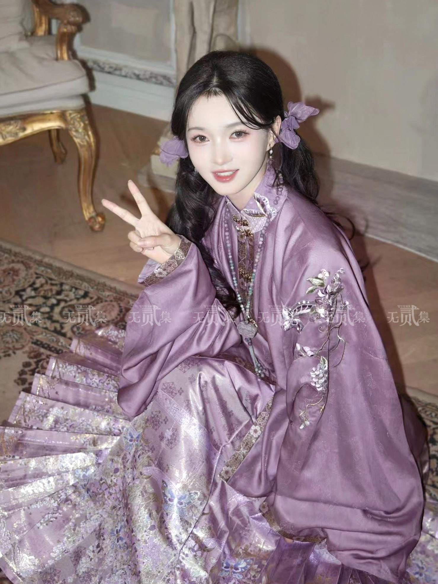 Close-up detail of violet Ming Dynasty Hanfu featuring floral sleeve embroidery, decorative collar trim, satin fabric, and metallic gold wisteria Mamianqun pattern