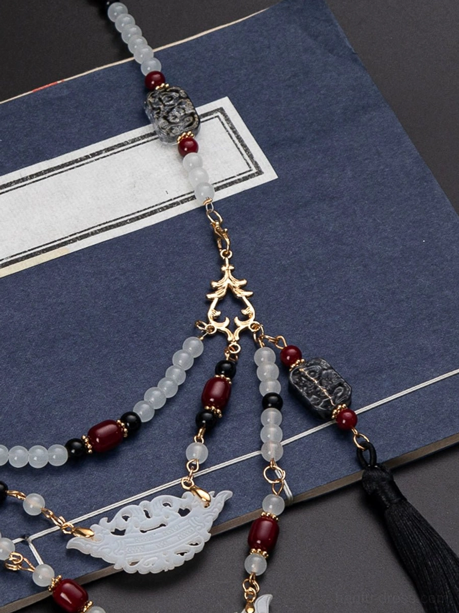 Close-up lower pendant layer of Warring States Chinese necklace featuring carved white jade-style charm gold chains and long beaded drops