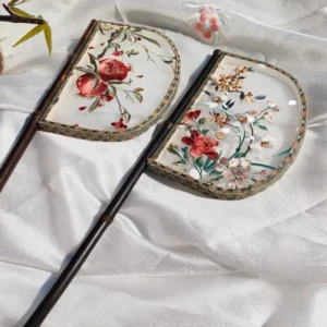 Flowers style half-moon embroidered Chinese hand fan with dark bamboo handle and decorative stitched edge on white satin