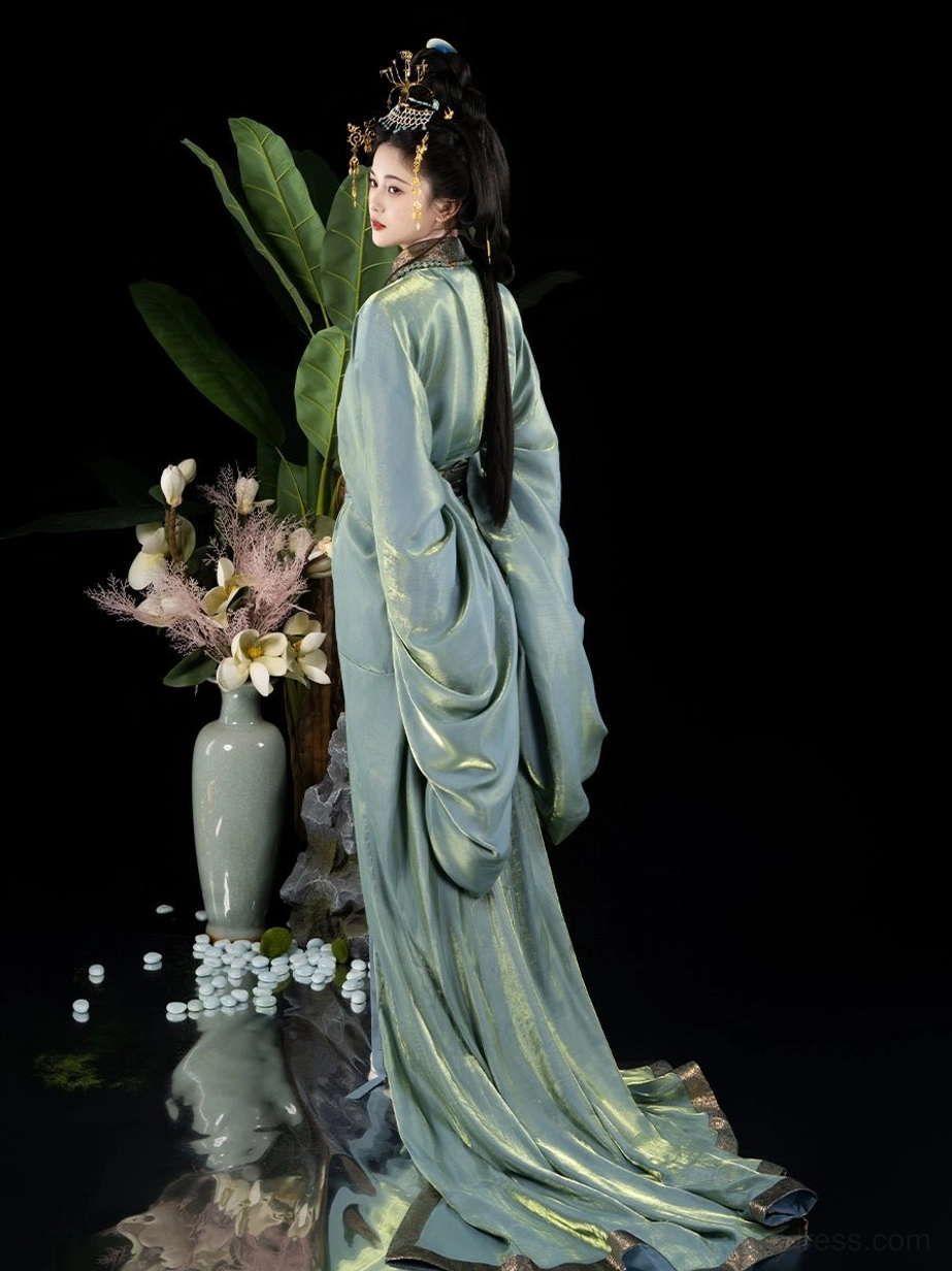 Rear view of a long Warring States and Han Dynasty hanfu robe showing the dusty cyan blue satin fabric, elegant floor-length train, and flowing traditional silhouette