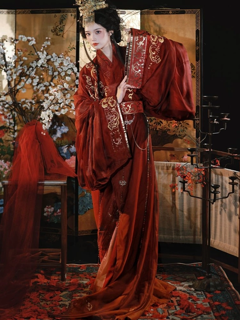 Full-body side view of a woman wearing a flowing Warring States and Han Dynasty Hanfu with wide sleeves, long straight hem, reddish-brown fabric, and ornate gold shoulder and collar embroidery