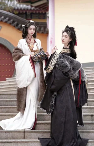 Two women wearing white and black Warring States and Han Dynasty Hanfu straight hem robes with layered shawls and traditional hairstyles on ancient temple stairs