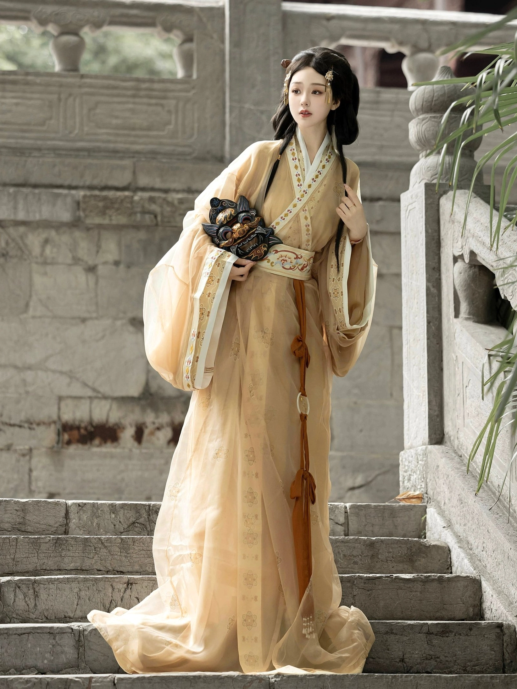 Yellow beige Warring States Han Dynasty straight hem Hanfu robe set with sheer wide sleeves and embroidered belt in a traditional stone courtyard