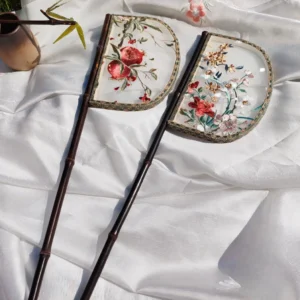 Two Warring States inspired half-moon embroidered Chinese hand fans with floral and pomegranate designs on white satin fabric