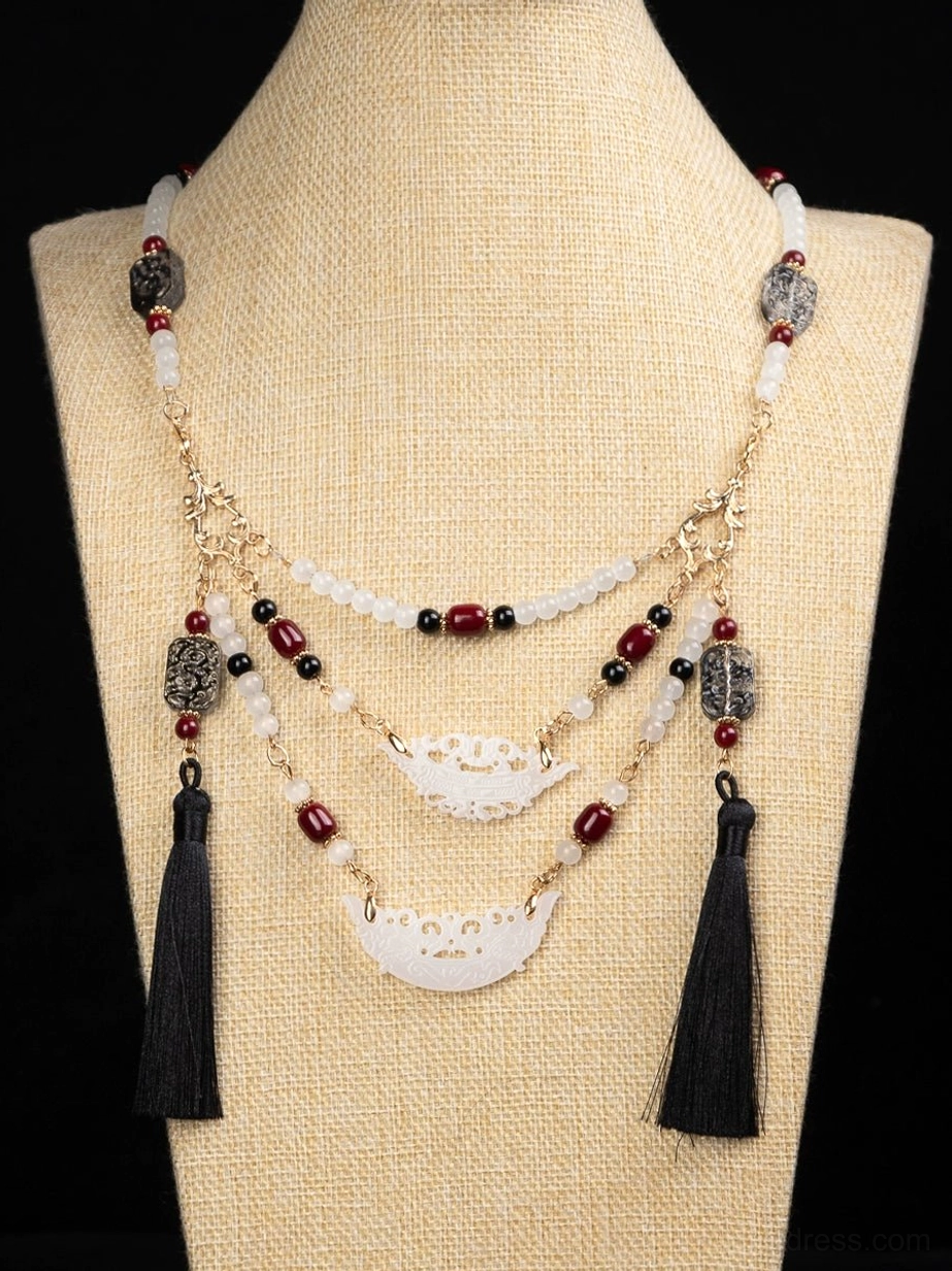 Warring States inspired multilayer Chinese necklace displayed on a linen dress form with burgundy beads carved white pendants and black tassels