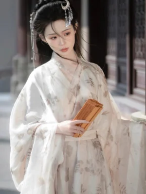 Half-body view of Wei Jin Dynasty Hanfu with a cross V-neck collar, subtle ink-wash floral pattern, loose sleeves and white waist sash beside traditional carved wooden doors