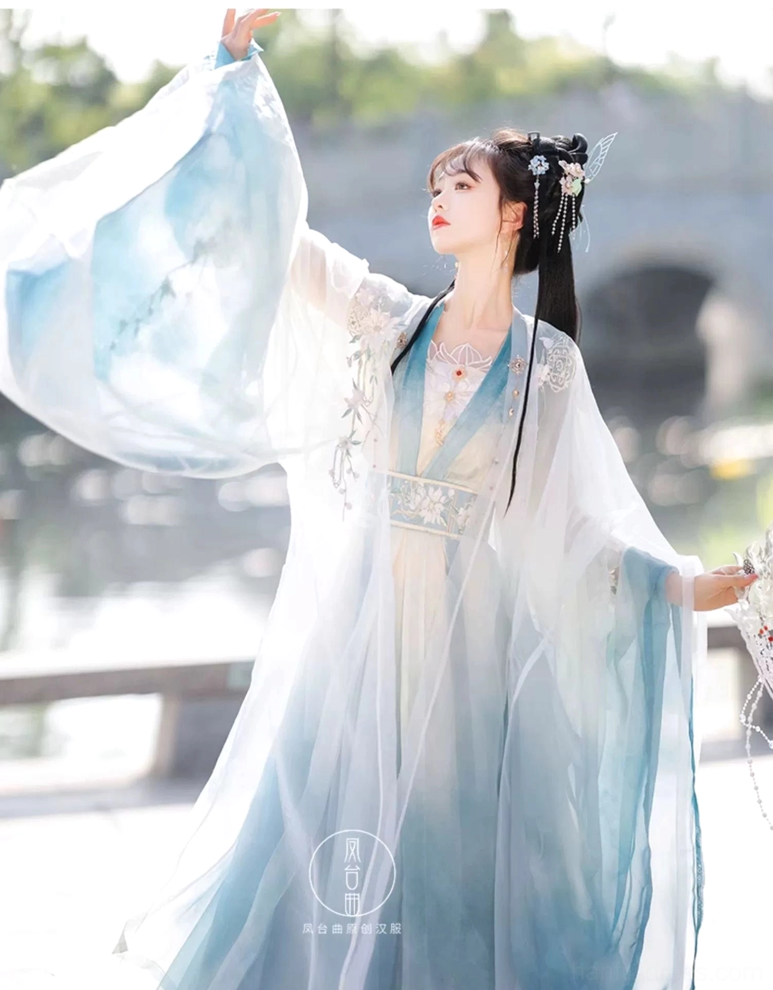 Side view of Wei Jin Dynasty Hanfu with cyan and ivory gradient fabric wide flowing sleeves and embroidered waist panel