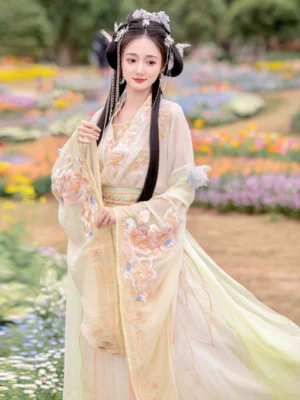 Wei Jin Dynasty Hanfu model standing in a flower field, showing the flowing gradient skirt, embroidered wide sleeves, and romantic xianxia-inspired traditional Chinese styling