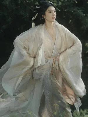 Wei Jin Dynasty Hanfu xianxia costume shown in a three-quarter front full-body view with flowing wide sleeves and a tied waist sash in a woodland waterside setting