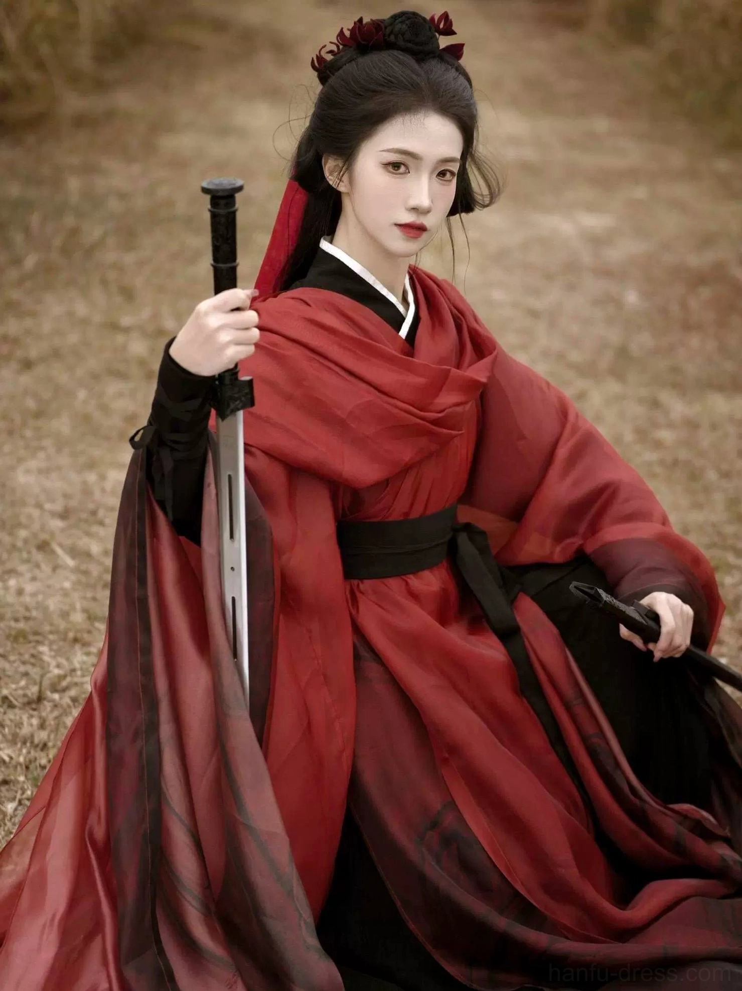 Wei Jin Dynasty knight style Hanfu model holding a sword and scabbard, featuring a black waist belt, red shoulder sash, cross collar, and layered sheer robe