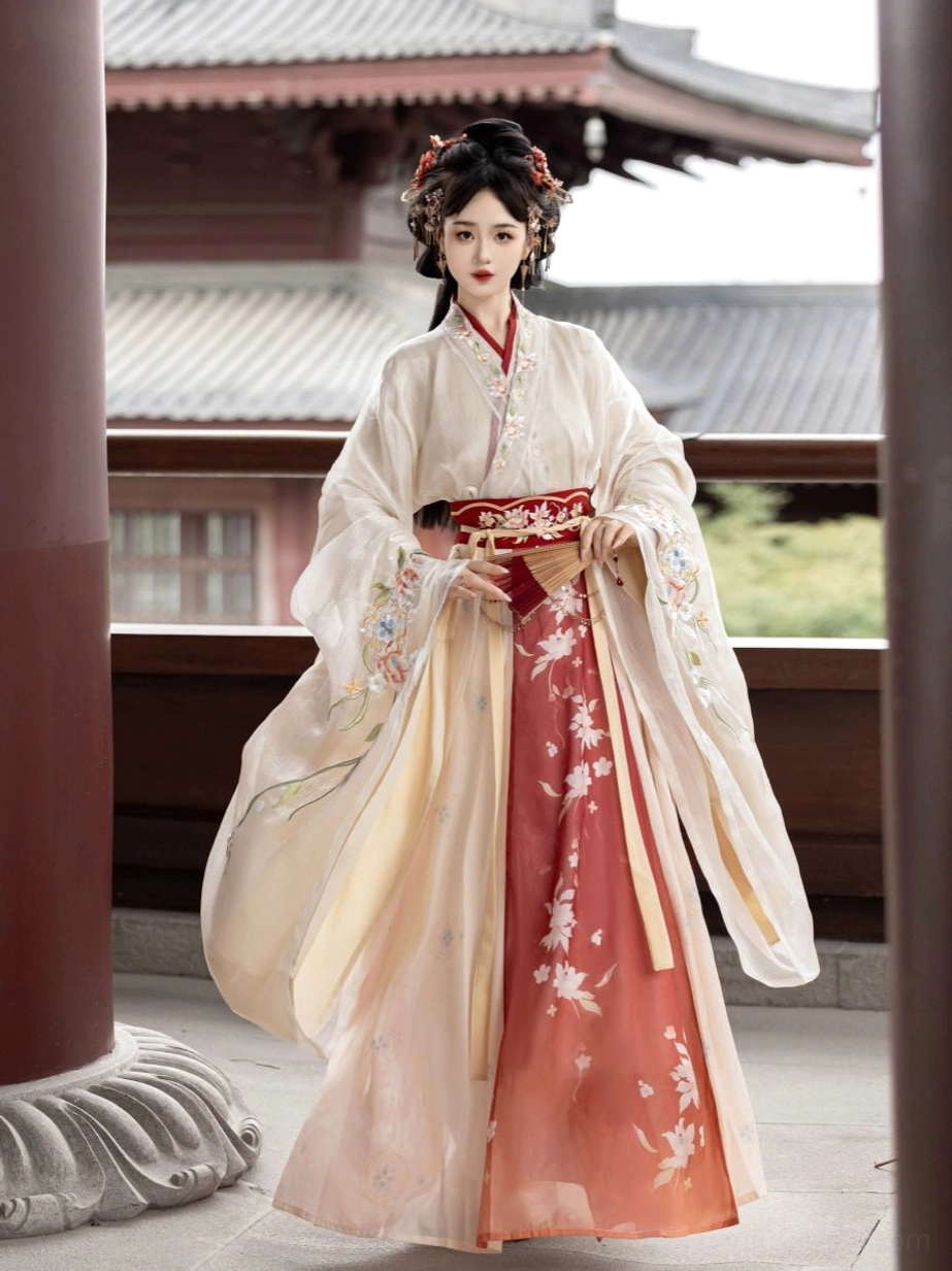 Cream to reddish-orange Wei Jin Dynasty Qiyao Ruqun Hanfu full front view with embroidered waist trim, floral gradient skirt, and flowing wide sleeves beside a red courtyard pillar