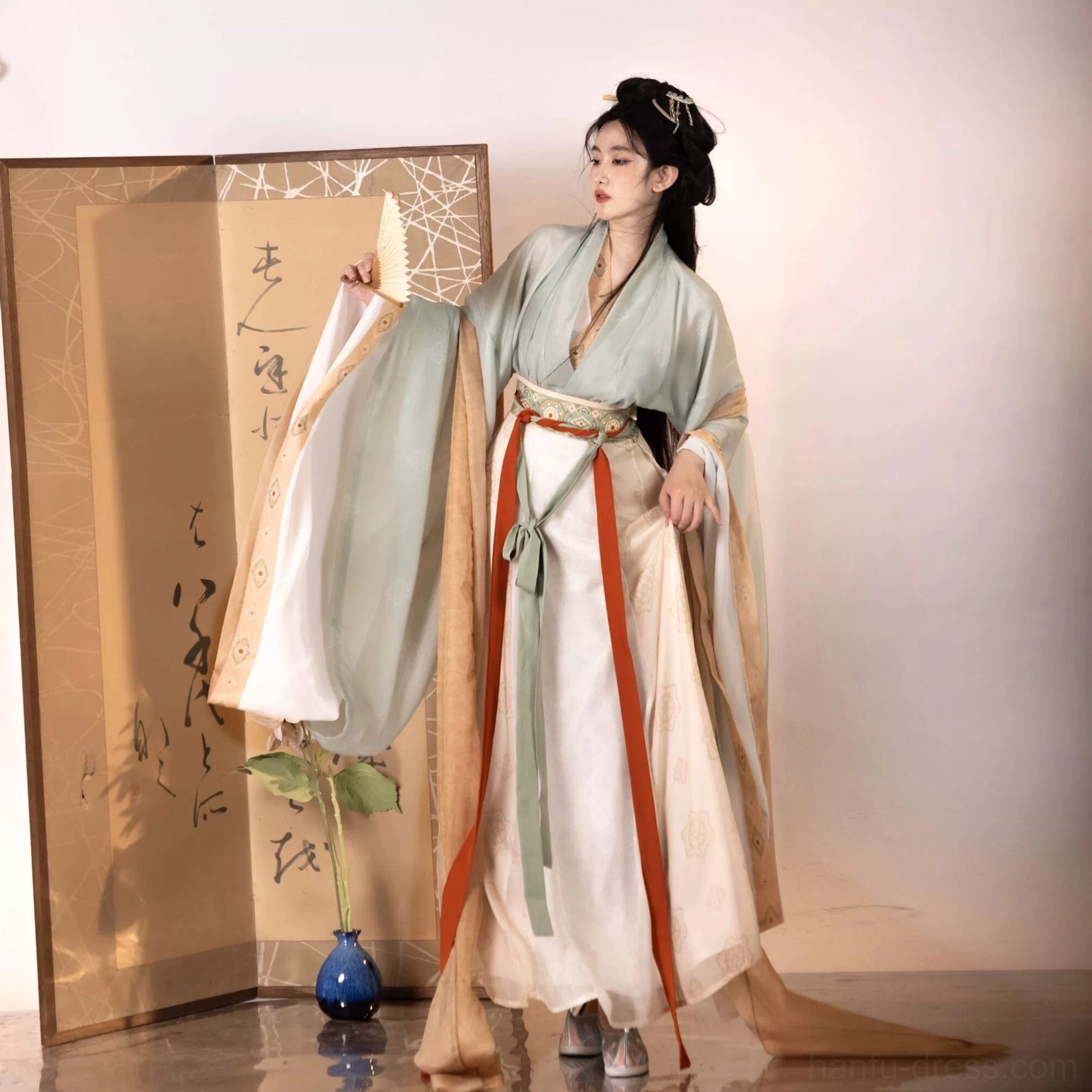 Three-quarter side view of light cyan and green Wei Jin Dynasty Qiyao Ruqun Hanfu with long trailing waist sash and flowing sleeves