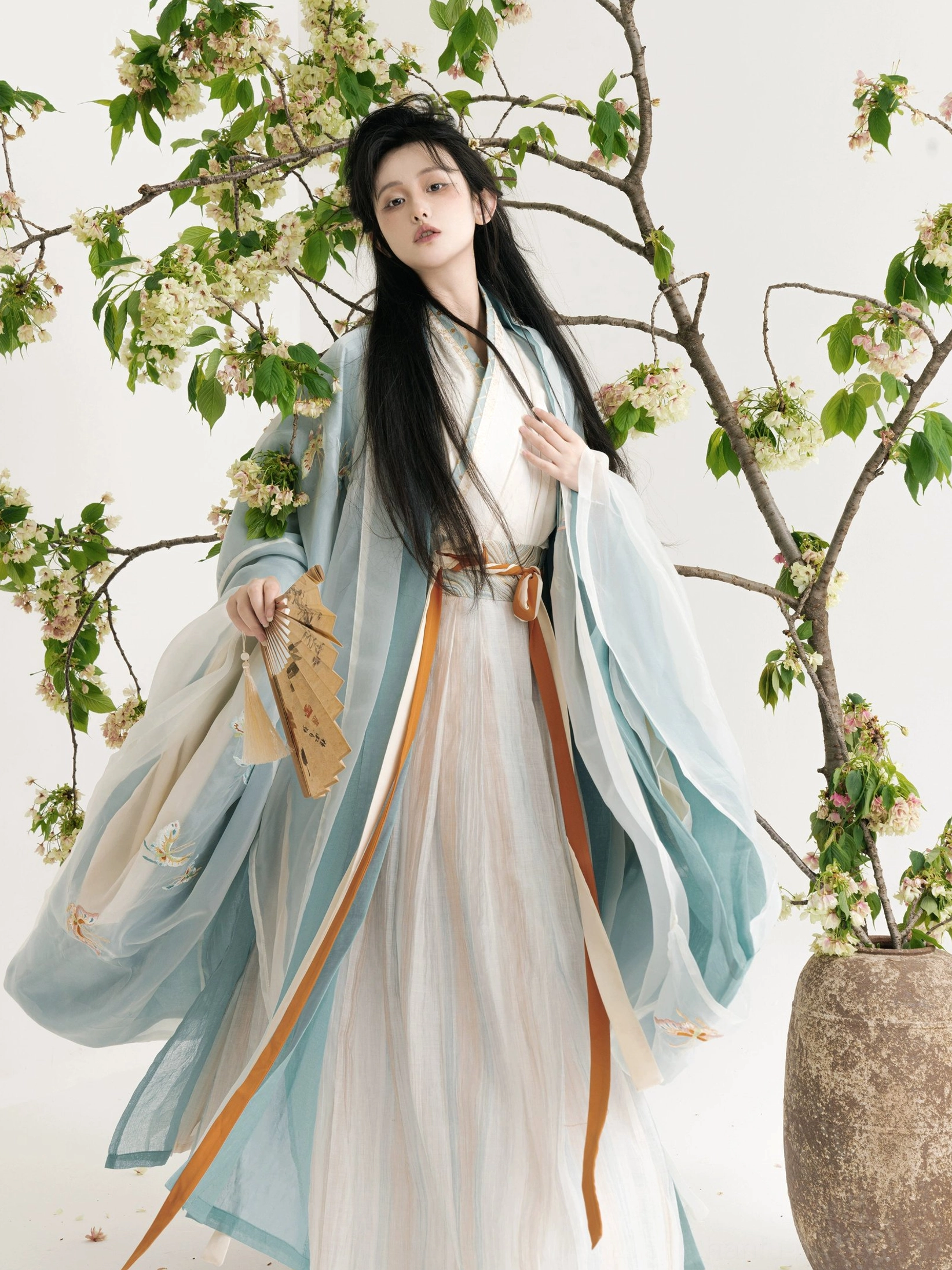 Wei Jin Dynasty Qiyao Ruqun Hanfu three quarter front view with dusty blue wide sleeves butterfly embroidery ivory inner dress and dual tone waist ribbons
