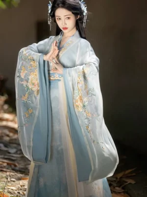 Half-body front view of dusty blue Wei Jin style Qiyao Ruqun Hanfu with golden floral embroidery on the wide sleeves and skirt and a contrasting traditional waist trim