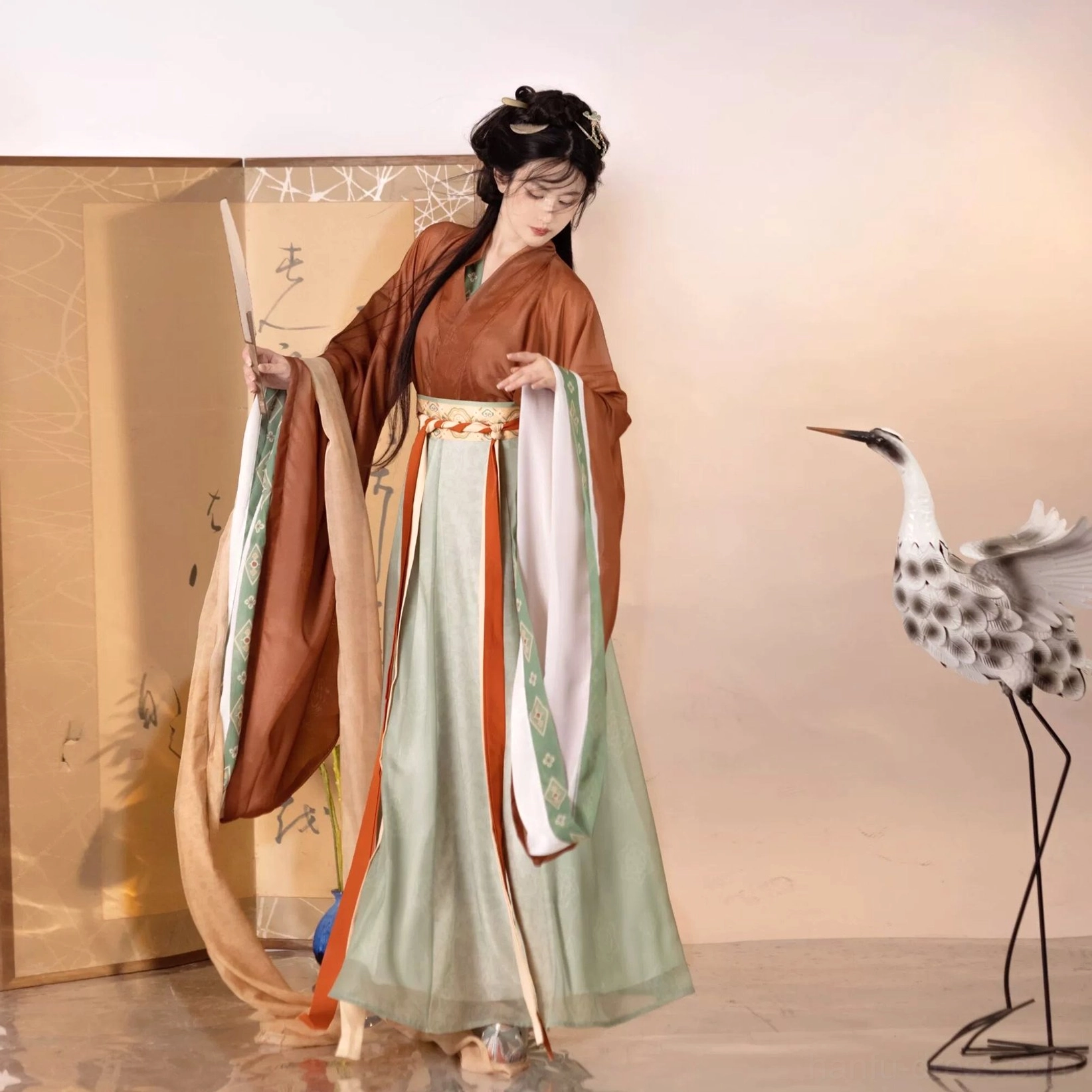 Side view of rust red, green, and white Wei Jin Dynasty Qiyao Ruqun Hanfu with pleated skirt, orange trim, and trailing outer sash