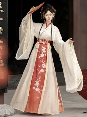 Red and cream Wei Jin Dynasty Qiyao Ruqun Hanfu three-quarter view featuring a floral gradient wrap skirt, cross-collar top, wide sleeves, and decorative red waist chain