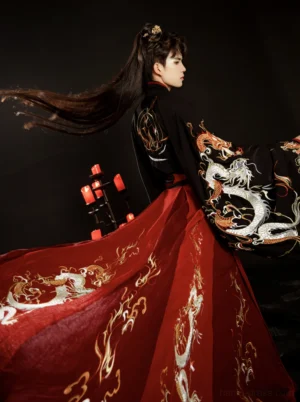 Rear three-quarter view of a male model wearing a wine red Wei Jin Dynasty Chinese wedding Hanfu groom outfit with black cross-collar robe, white dragon embroidery, golden flame details, wide sleeves, and a flowing long train