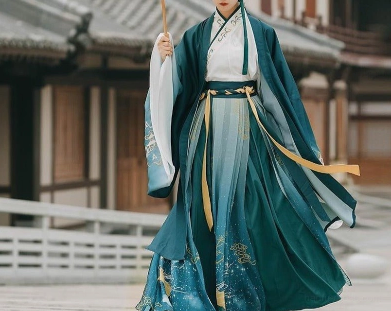 Full-length Wei Jin style qiyao ruqun hanfu with yellow waist belt, starry skirt hem, and cross-collar inner top in front of traditional wooden buildings