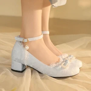 White traditional Chinese Hanfu shoes worn on female feet, featuring jacquard woven uppers, ruffled lace collars, beaded bow toe decorations, pearl ankle ornaments, and low square block heels