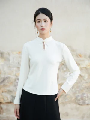 White Chinese style fitted knit top front view showing elegant stand collar decorative closure long sleeves and black high-waisted skirt styling