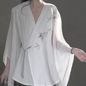 White cotton linen Hanfu top close up showing bamboo leaf embroidery, textured fabric, wrap V neckline, and adjustable drawstring waist