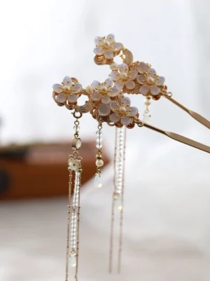 Front flat lay of matching left and right white flower Chinese hair sticks with long shimmering beaded tassels for Hanfu hairstyle styling