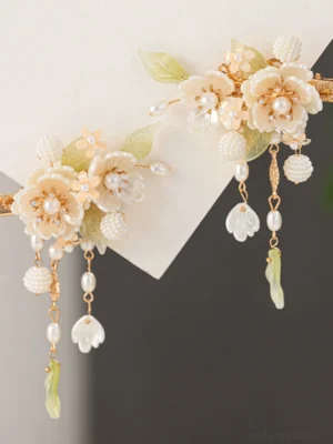 Pair of white flower Hanfu hair clips with faux pearl centers, pale green leaves, gold-tone frames, and dangling pearl tassels