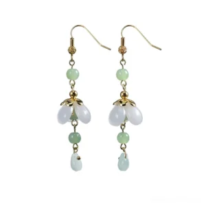 Pair of white glass flower drop earrings with gold tone hooks green round beads and glossy light green teardrop charms on a white background