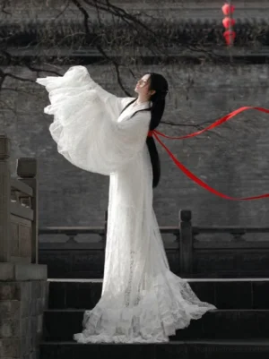 White Han Dynasty Hanfu straight hem robe with flowing lace sleeves ruffled floor length train and red back ribbon on ancient stone stairs