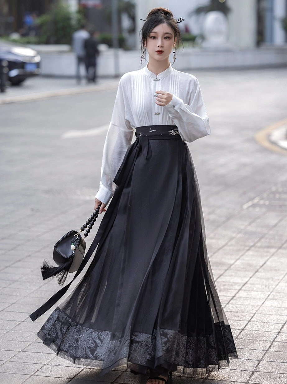 White stand collar Hanfu blouse and black sheer mamian skirt outfit shown in an urban street setting