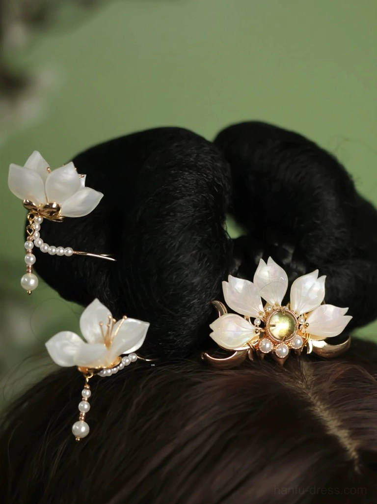 White lotus Hanfu hair pins and pearl tassel hair ornaments arranged on traditional Chinese hair buns