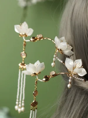 White lotus pearl tassel Hanfu hair pin displayed in an ancient Chinese style hair bun with gold tone branches and brown bead details