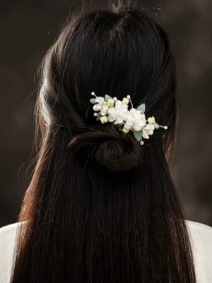 White magnolia floral Hanfu hair comb with green leaves styled in the back of long black hair for a traditional Chinese hairstyle