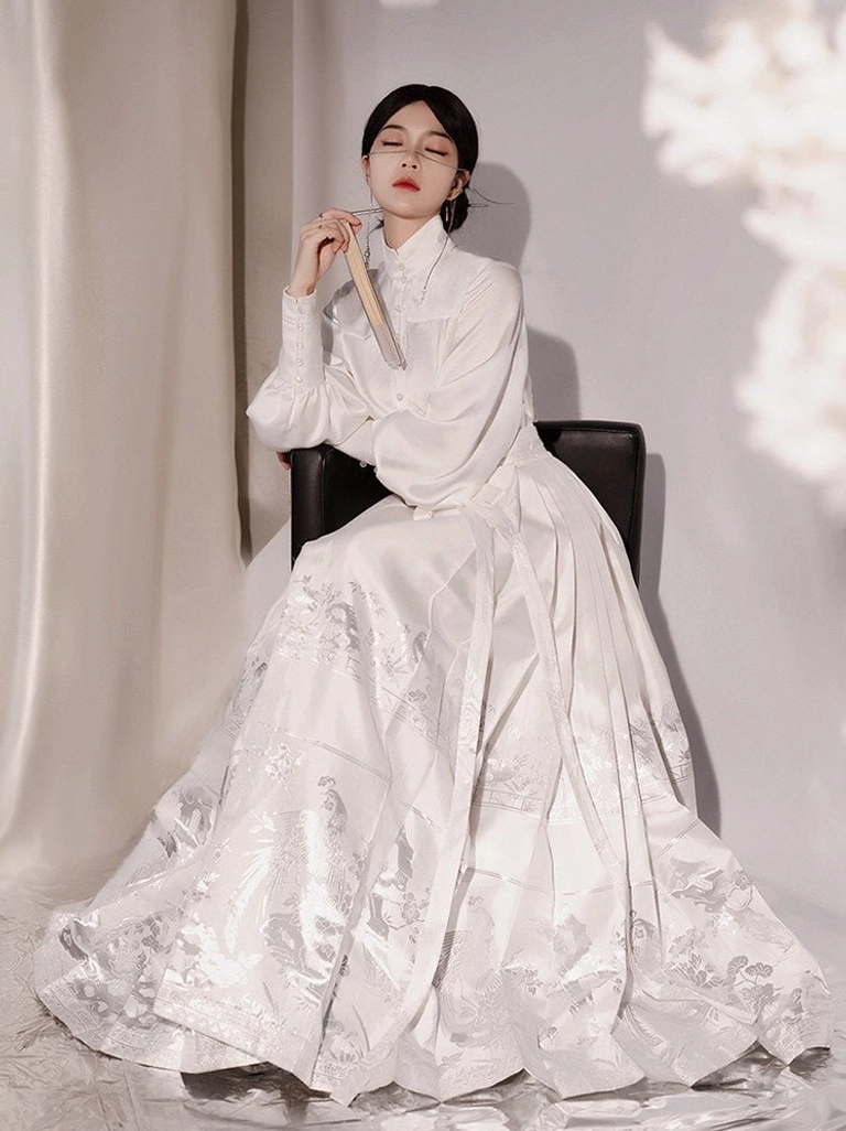 White Ming Dynasty inspired Hanfu full set with stand collar blouse and jacquard mamianqun horse face skirt in front three quarter seated view