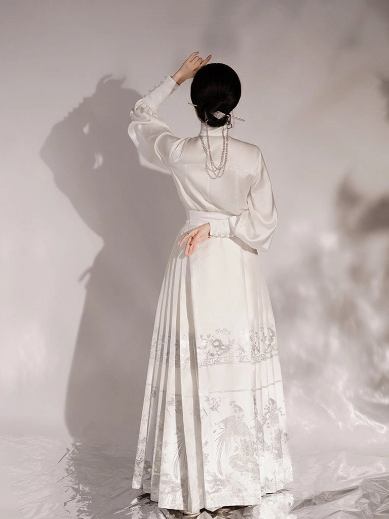 Back view of white Ming Dynasty Hanfu outfit showing long pleated mamianqun horse face skirt with bird and floral jacquard motifs