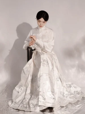Close up of white Ming style Hanfu stand collar long sleeve top with front buttons and subtle glossy woven floral pattern