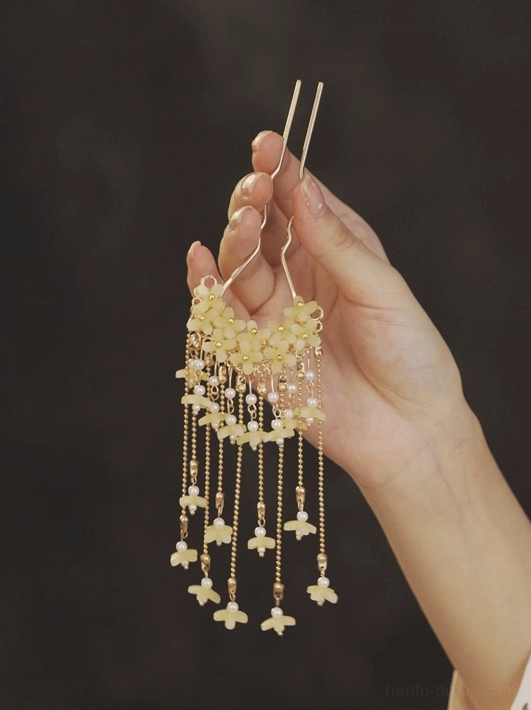Hand holding wind chimes floral tassel Chinese Hanfu hair pin with pearl like beads, gold tone chains, and double prong hair fork