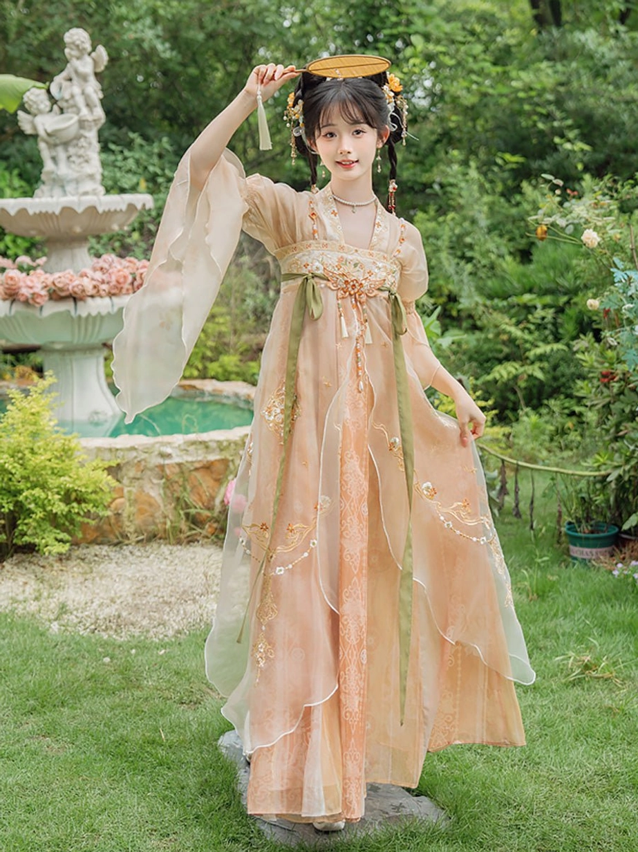 Tang Dynasty qixiong ruqun Hanfu dress shown in a garden with sheer apricot gradient fabric, floral embroidery, long green sashes, and tassel decorations