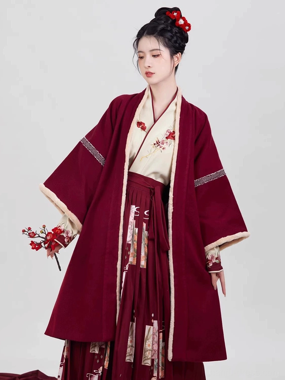 Side view of a wine red Song Dynasty hanfu ensemble with floral embroidered inner top, printed pleated skirt, and decorative striped sleeve trim