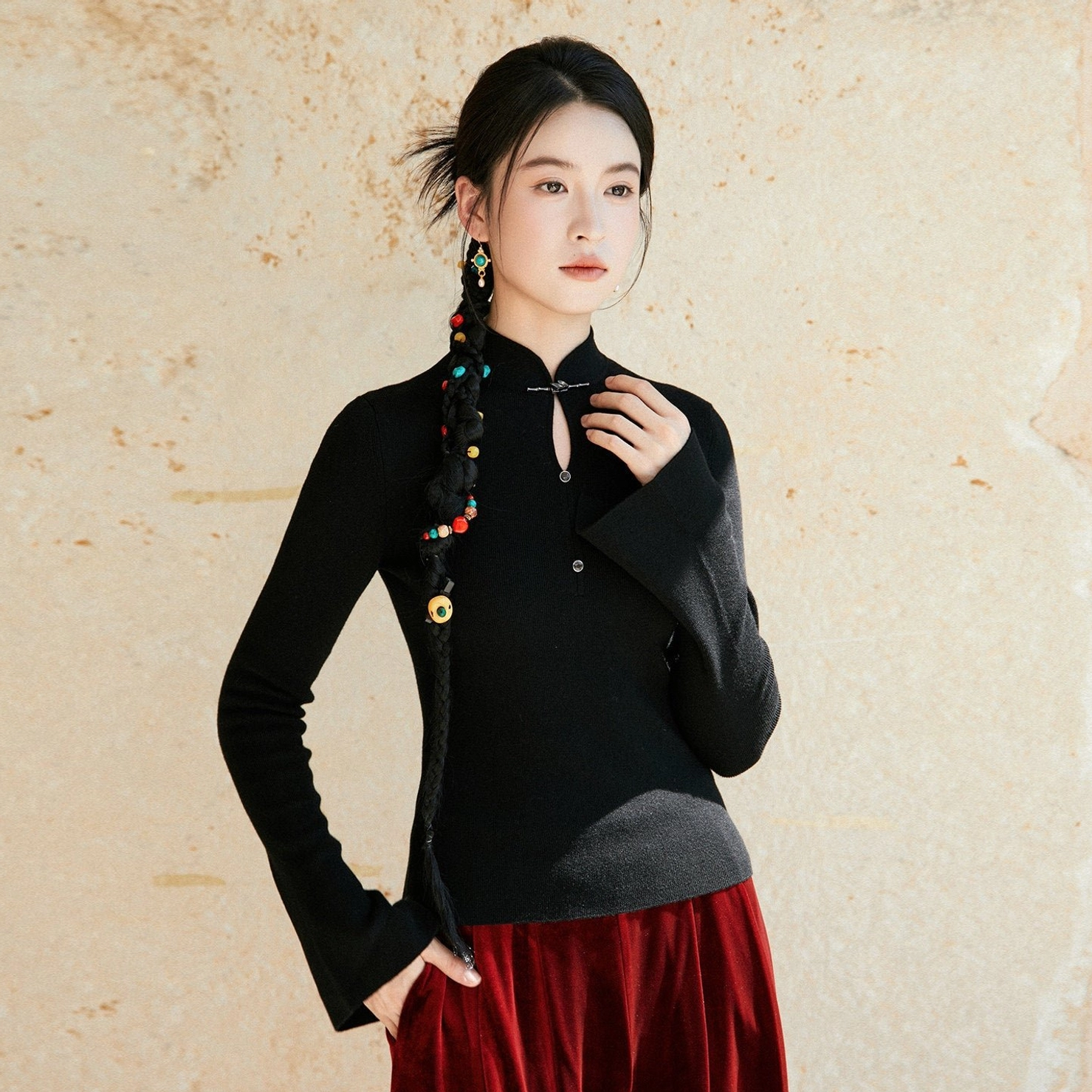 Black Chinese inspired modern Hanfu wool knit sweater with stand collar frog buttons styled with burgundy velvet skirt three-quarter view