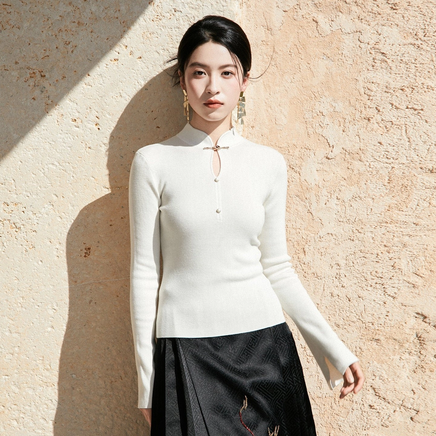 White modern Hanfu wool sweater with Chinese stand collar frog button closure ribbed knit texture and flared sleeves front view
