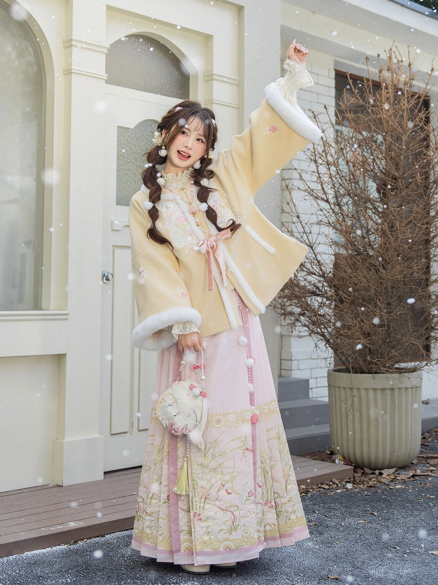 Side view of a winter Chinese Hanfu clothing set with beige fleece lined jacket, floral pink Mamian skirt, and plush handbag